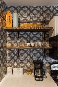 a kitchen with shelves and a coffee maker on a counter at Villa Dubois Guest House in Chicago