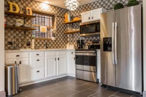 a kitchen with white cabinets and a stainless steel refrigerator at Villa Dubois Guest House in Chicago