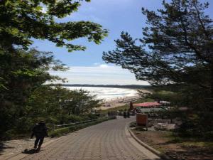 een persoon die over een bakstenen pad loopt naast een strand bij Ferienhaus Sonnensteg in Ostseebad Sellin