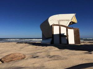een stoel op een strand naast een rots bij Ferienhaus Sonnensteg in Ostseebad Sellin +13 foto's