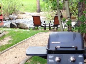 two chairs and a grill in a yard at Swiftcurrent Lodge in Estes Park