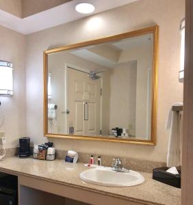 a bathroom with a sink and a large mirror at Baymont by Wyndham Grand Rapids SW/Byron Center in Byron Center