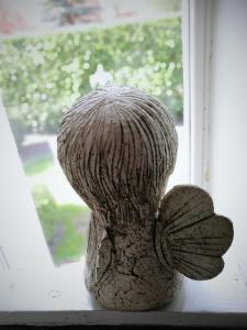 Uma estátua de um urso de peluche sentado no peitoril da janela. em Guest house ''8 Smilgos'' em Klaipėda