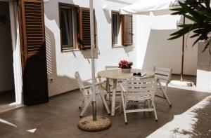 une terrasse avec une table, des chaises et un parasol dans l'établissement Casa del mare, à Capitolo