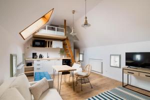 a living room with a couch and a table with chairs at Skyway Apartment in Toruń
