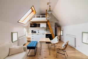 a kitchen and living room with a table and chairs at Skyway Apartment in Toruń