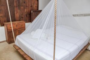 a bed with a net canopy in a room at Cabañas Biuzaa in Zipolite