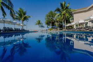 a large swimming pool with palm trees and palm trees at Beach Hotel Juquehy in Juquei