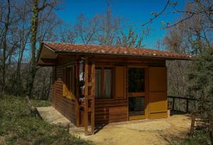 a small cabin with a large door in a field at CHALET NEL BOSCO - TENUTA BOCCHINERI in Rogliano