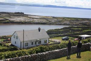 um homem parado no telhado de uma casa em Cliffs of Moher View em Inisheer