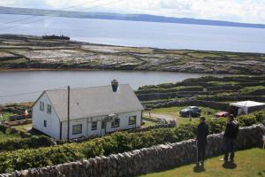 un hombre parado en el techo de una casa en Cliffs of Moher View, en Inis Oírr