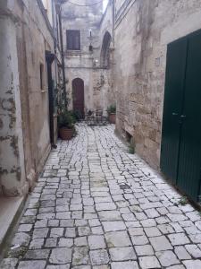 un vicolo con passerella in pietra in un vecchio edificio di La Rosa dei Sassi 2 a Matera