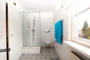 a white bathroom with a shower and a toilet at Private Rooms in Hannover