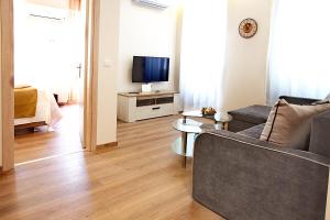 - un salon avec un canapé et une télévision dans l'établissement Liston Inn Suites(Plaza) - Heart of Corfu Old Town, à Corfou