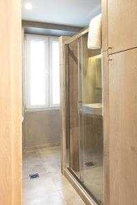 - une douche en verre dans une chambre avec fenêtre dans l'établissement Liston Inn Suites(Plaza) - Heart of Corfu Old Town, à Corfou
