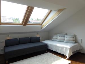 a bedroom with a bed and a couch in a attic at Truchtling Appartements in Seeon-Seebruck