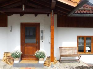una casa con una porta in legno e una panca di Truchtling Appartements a Seeon-Seebruck