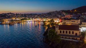 a view of a city with a harbor at night at Pela Veranda Exquisite Suites in Neos Marmaras