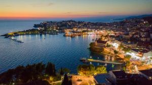 a view of a city with a harbor at night at Pela Veranda Exquisite Suites in Neos Marmaras