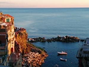 a group of people standing on a cliff near the ocean at Meb in Riomaggiore