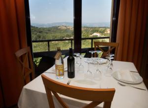 Hotel Restaurante Novella في بيناسال: طاولة مع زجاجة من النبيذ والاكواب