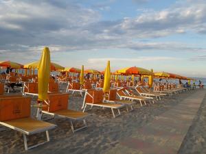 a row of chairs and umbrellas on a beach at Casa a Cervia, via Gargano 14 in Cervia