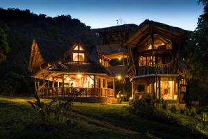 ein großes Holzhaus in der Nacht mit Lichtern in der Unterkunft Sacha Urco Lodge y Bosque Protector in Mindo