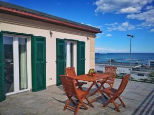 a patio with a table and chairs and the ocean at Appartamento deluxe con terrazza sul mare in Savona