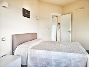 a bedroom with a bed in a white room at Appartamento deluxe con terrazza sul mare in Savona