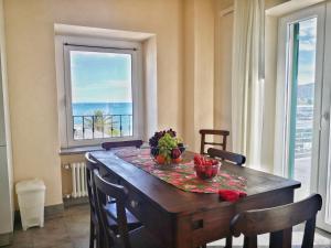 a dining room table with a view of the ocean at Appartamento deluxe con terrazza sul mare in Savona +15 photos