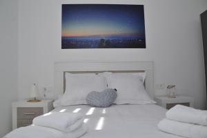 a bedroom with a white bed with a heart pillow at TERUEL CON AMOR in Teruel