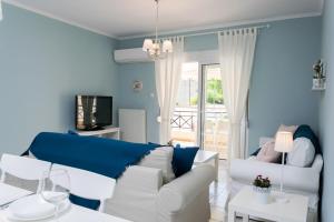 - un salon avec un canapé blanc et des murs bleus dans l'établissement Casa di Emma, à Néa Péramos