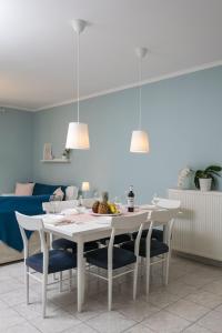 une salle à manger avec une table et des chaises blanches dans l'établissement Casa di Emma, à Néa Péramos