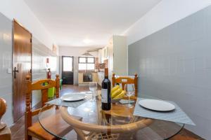 a dining room with a table with a bottle of wine at Safari Beach guest house in Lagos