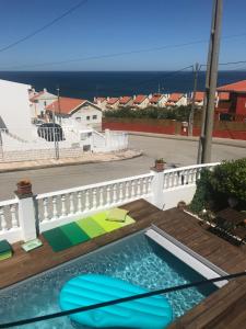 una piscina su una terrazza con vista sull'oceano sullo sfondo di MappaMundo a Ribamar