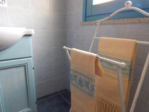 La salle de bains est pourvue d'un sèche-serviettes et d'un lavabo. dans l'établissement S'Apposentu Teuladesu Affittacamere del Ristorante da Stefano, à Teulada