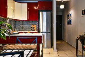 a kitchen with red cabinets and a stainless steel refrigerator at Star Acropolis Apartment in Athens