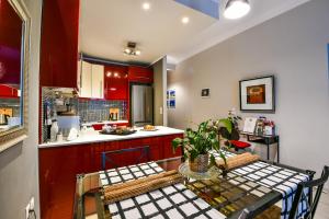 a kitchen with red cabinets and a table and a table and chairs at Star Acropolis Apartment in Athens