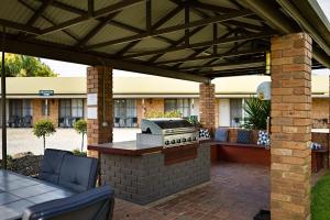 a patio area with a patio table and chairs at Statesman Motor Inn in Corowa