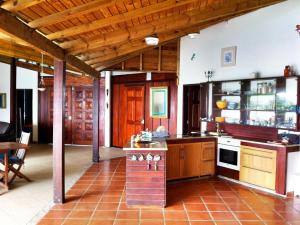 a large kitchen with wooden cabinets and a table at Wild Paradise: Villa vue mer piscine à débordement in Le Moule