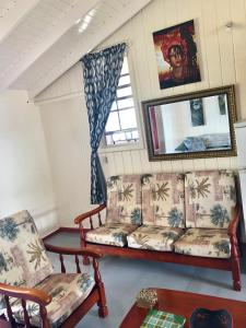 salon z kanapą i 2 krzesłami w obiekcie Rainbow Beach Apartments & Rooms w mieście Calibishie