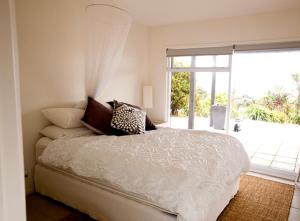 a bedroom with a bed and a sliding glass door at Bayview Retreat in Oneroa