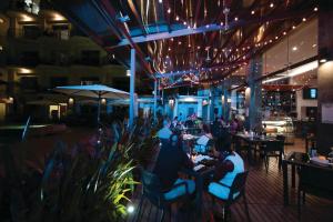 a group of people sitting at tables in a restaurant at PACIFIC SUITES Boutique Hotel and Bistro in Jacó