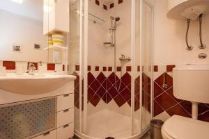 ein Bad mit einer Dusche, einem Waschbecken und einem WC in der Unterkunft Apartments Mediteranea in Baška