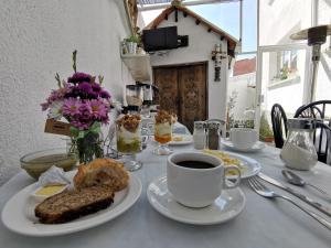 a table with a plate of food and a cup of coffee at Casa Fusion Hotel Boutique in La Paz