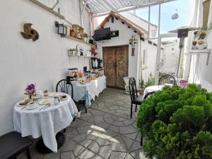 un patio con 2 mesas con mantel blanco en Casa Fusion Hotel Boutique, en La Paz