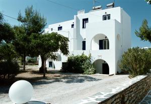 una casa bianca con degli alberi di fronte di Chrisanthi Studios ad Agios Prokopios