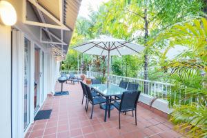 
a patio area with a patio table and chairs at Balboa Apartments in Port Douglas
