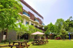 eine Gruppe Picknicktische vor einem Gebäude in der Unterkunft One City One Vacation Farm in Nantou