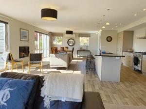 uma sala de estar e uma cozinha com um sofá e uma mesa em Loch View - Lake Tekapo em Lake Tekapo